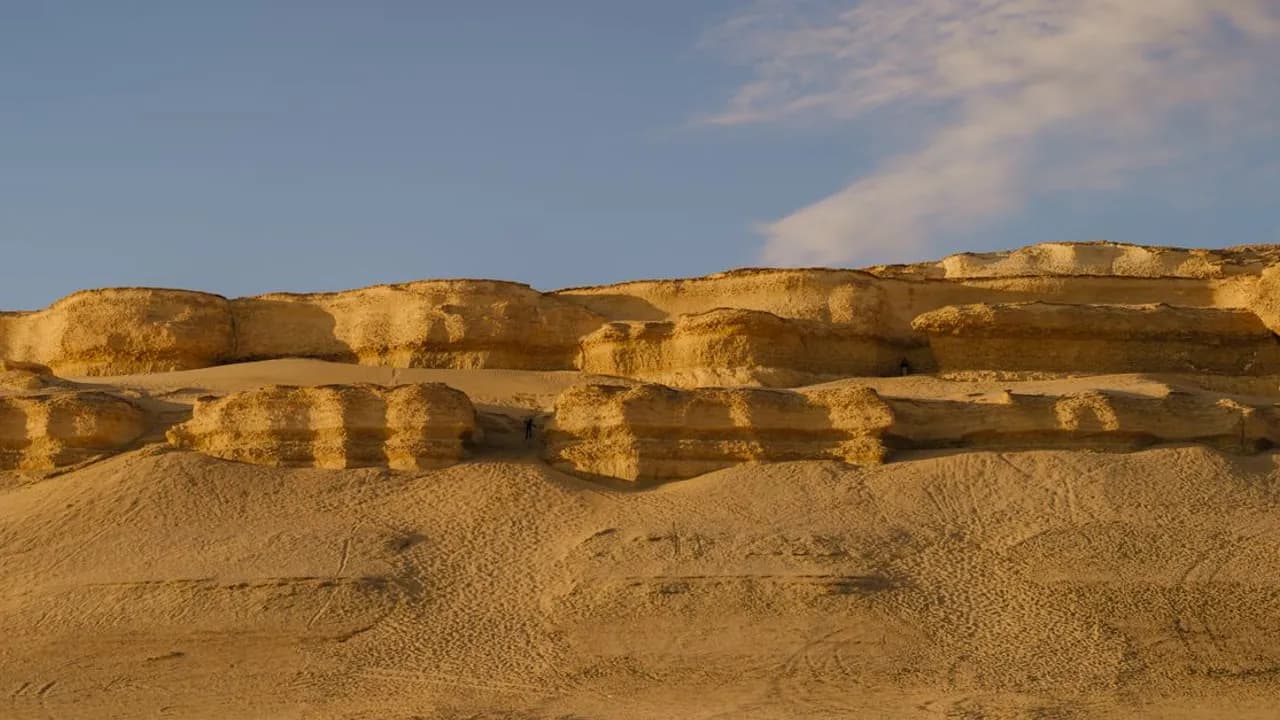 Sunlit sandstone cliffs rising above the desert near Faiyum, Egypt, at sunset