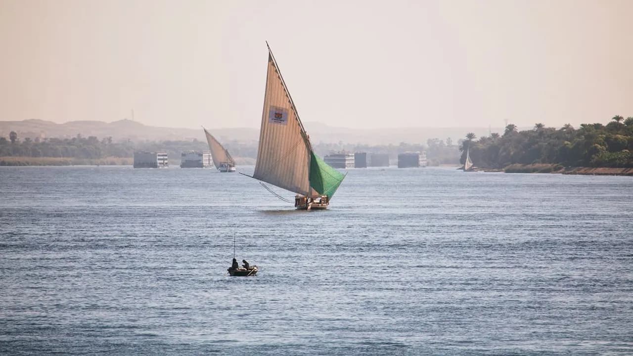 A traditional felucca sailing on the Nile at Luxor under a clear blue sky