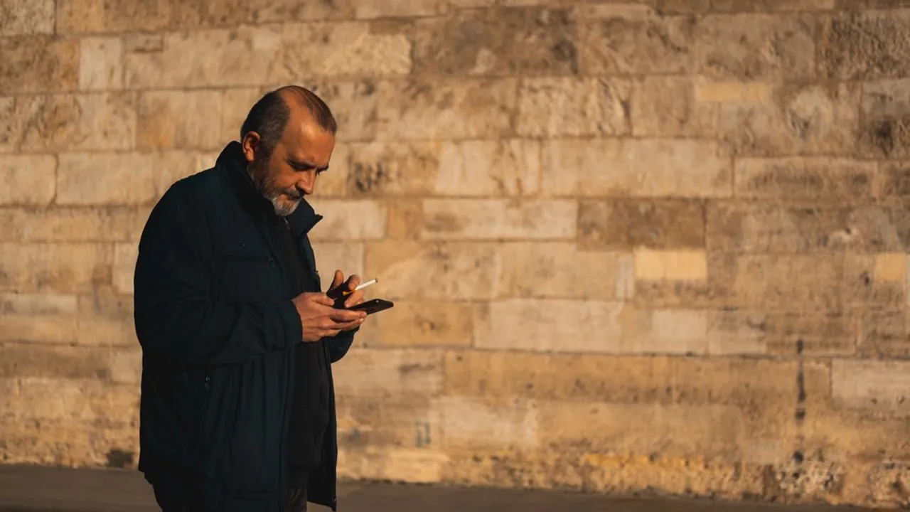 A traveler checking their smartphone's signal on a city street