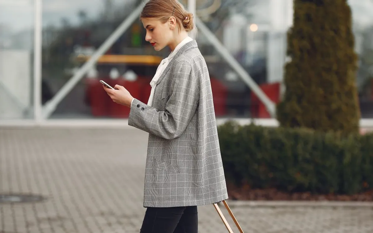 A traveler adjusting settings on her smartphone while waiting at the airport