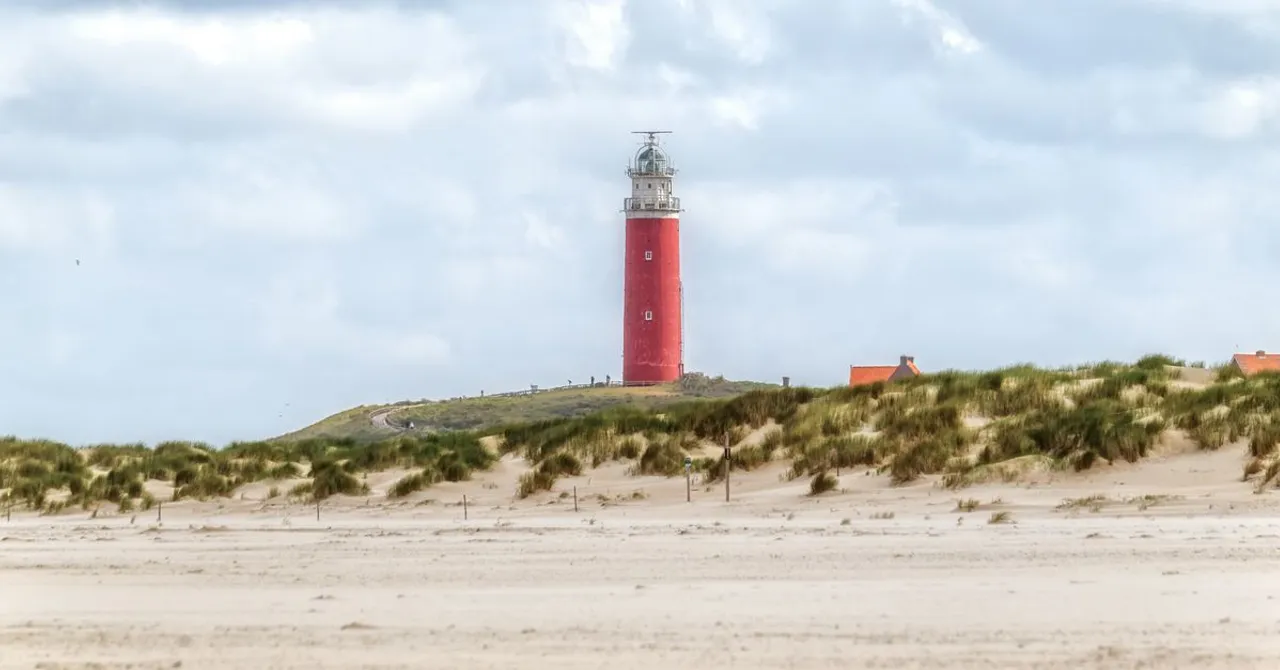 The red lighthouse on Texel, one of the Dutch Wadden Islands, surrounded by dunes
