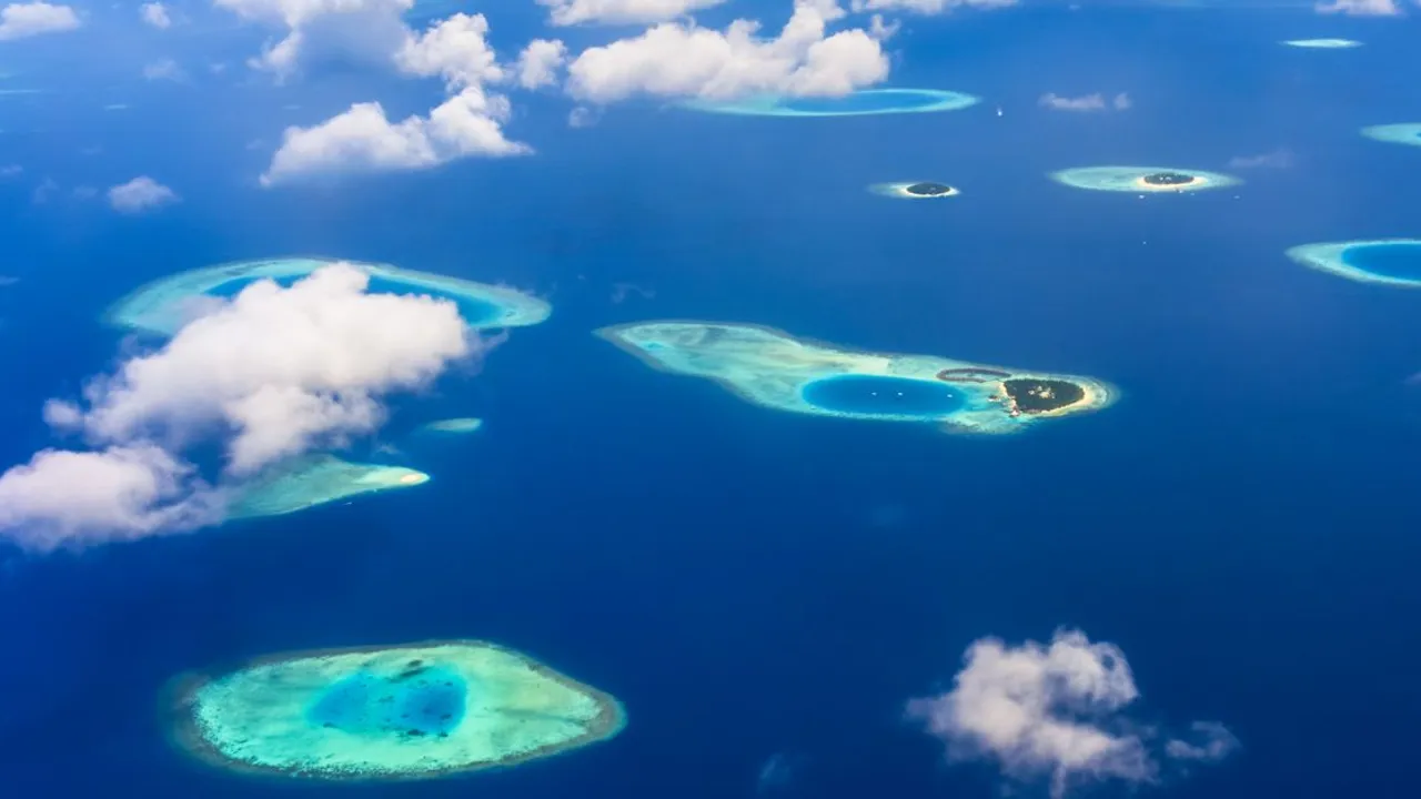 Aerial view of turquoise water and small forested islands in the Pacific
