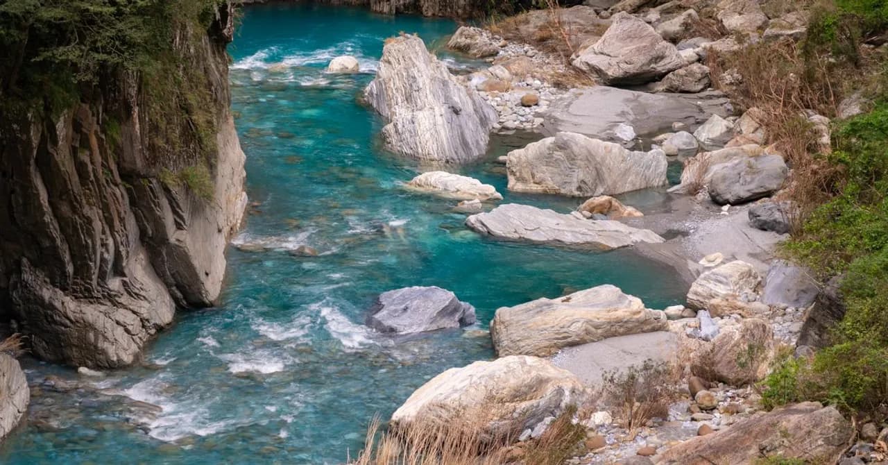 A turquoise river winding through the marble canyon walls of Taroko Gorge, Taiwan