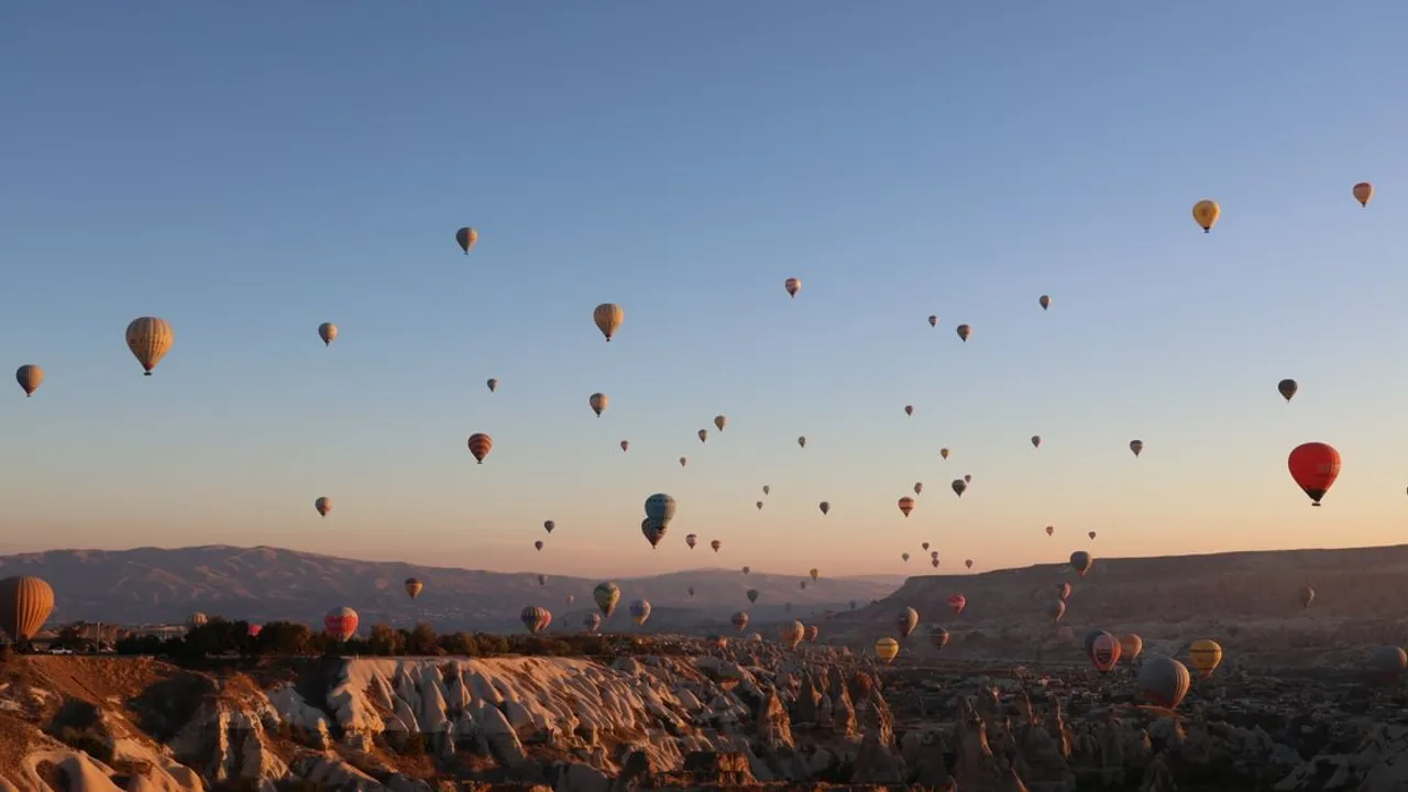 Hot air balloons floating over the rock formations of Cappadocia at sunrise