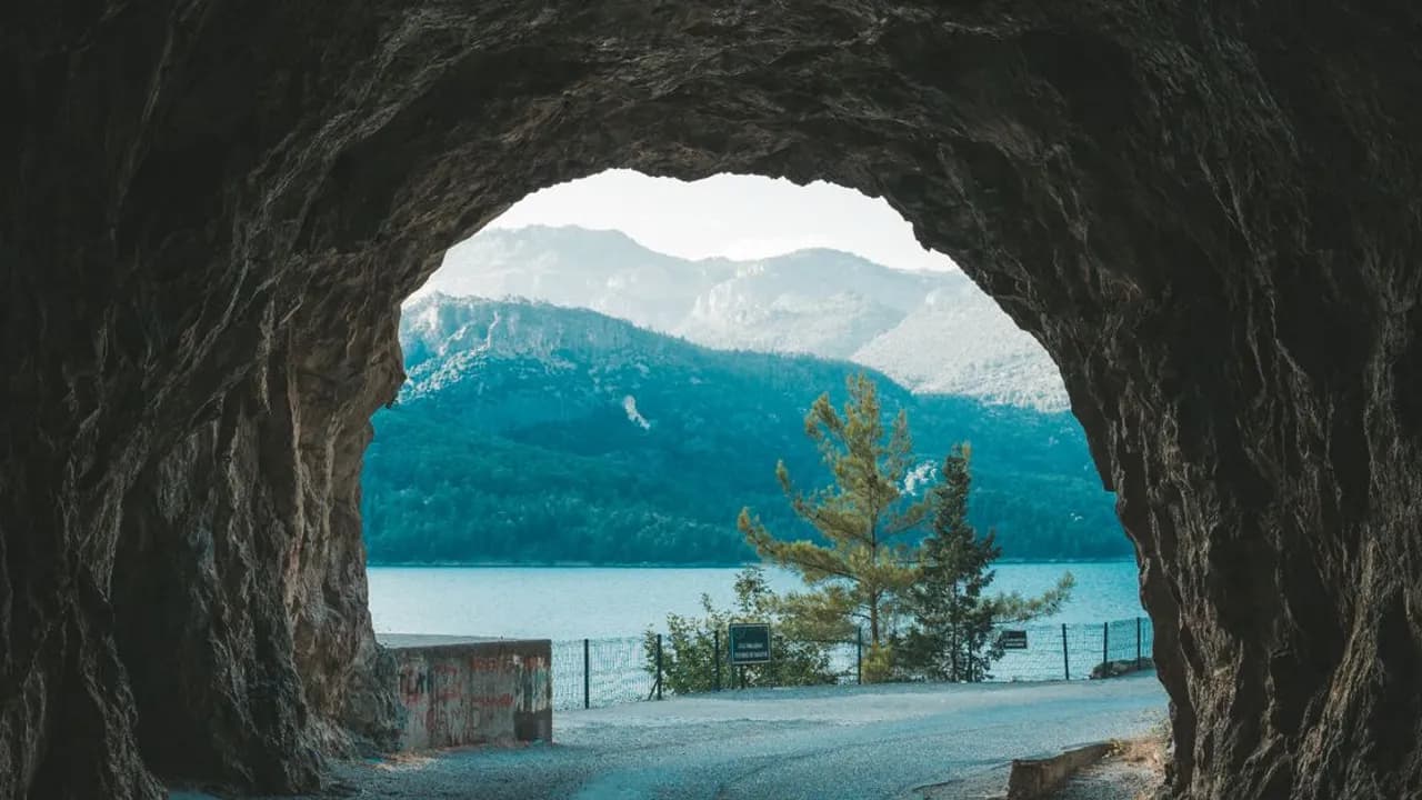 Mountains and a lake framed by a rocky road tunnel near Manavgat, Antalya