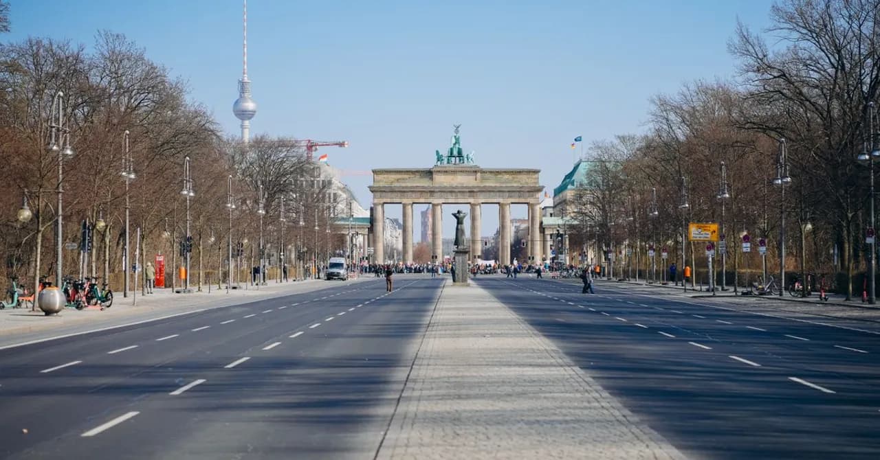 De Brandenburger Tor aan het eind van een brede Berlijnse laan, met de televisietoren erachter.
