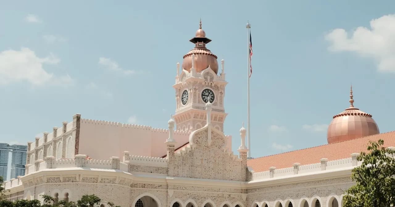 Ein Gebäude im maurischen Stil mit Kupferkuppeln und Uhrturm im Zentrum von Kuala Lumpur
