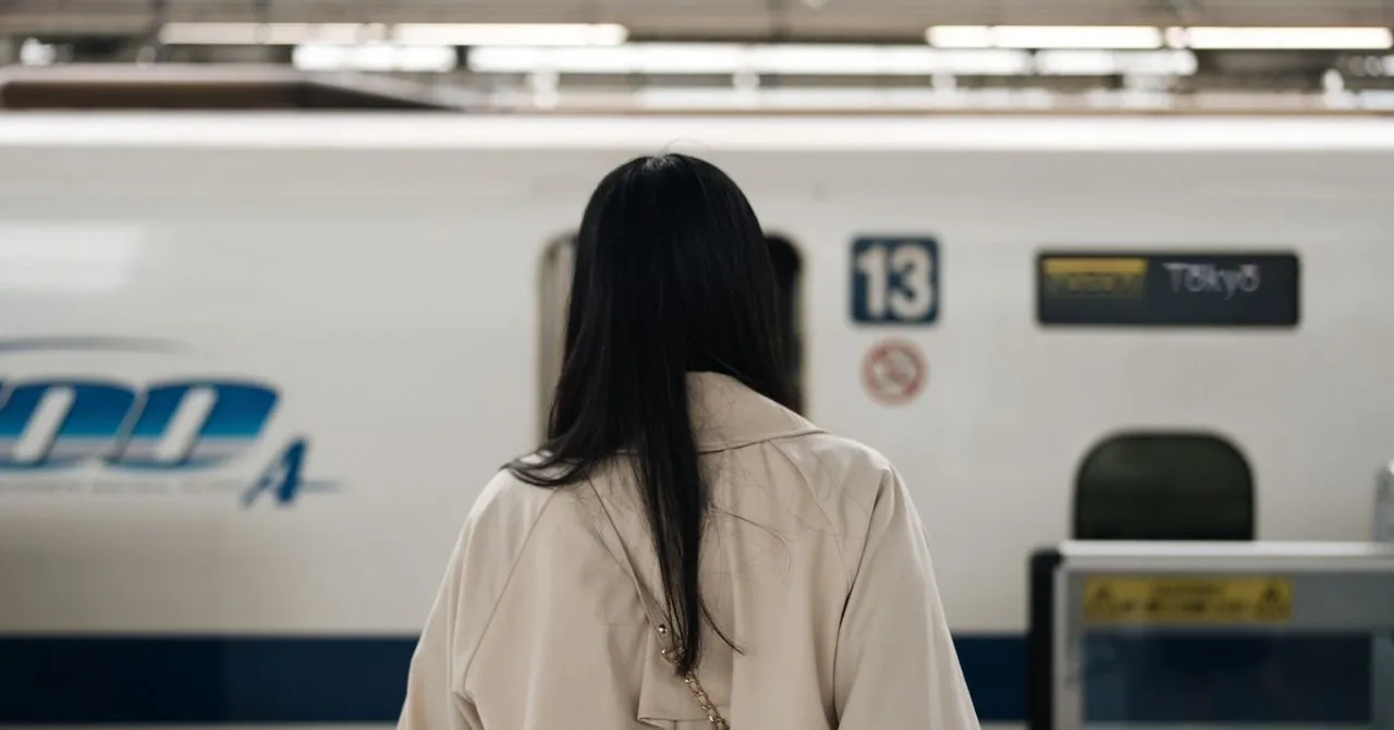 A shinkansen waiting at a Japanese station platform with passengers boarding