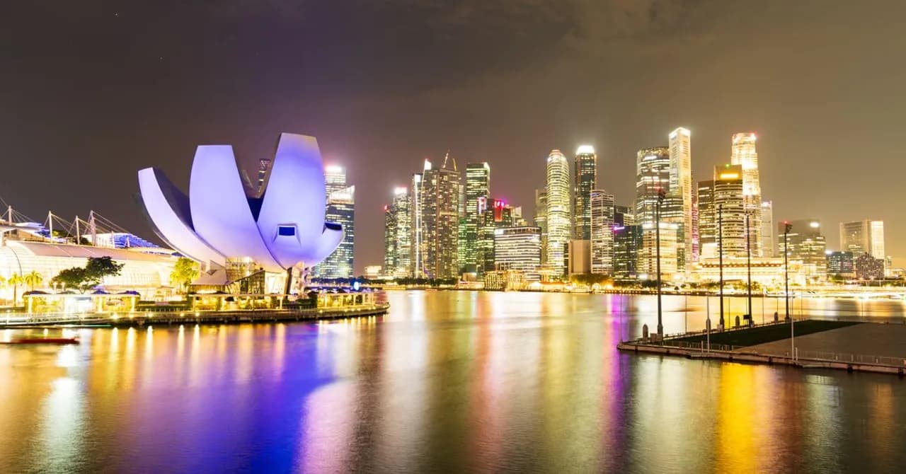 Die Uferpromenade an der Marina Bay in Singapur, nachts beleuchtet