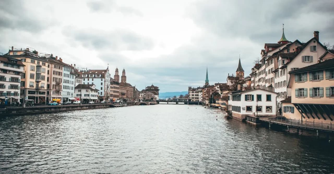 Häuser am Ufer und Kirchtürme entlang der Limmat in Zürich
